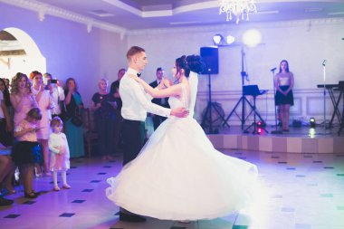 Güzel beyaz bir çift yeni evlendiler ve ilk danslarını ediyorlar.