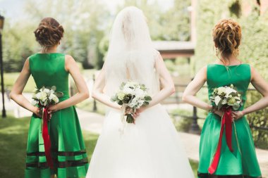 Gelin çiçekli büyük ve güzel bir düğün buketi tutuyor.