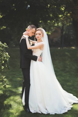 Güzel, mutlu bir düğün çifti, güzel şehirde uzun beyaz elbiseli bir gelin.