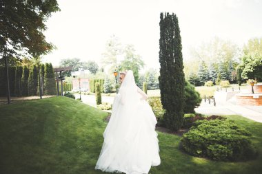 Gelinlik içinde dışarıda poz veren güzel gelin.