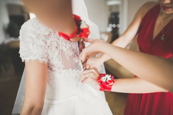 Preciosa novia en bata posando y preparándose para la ceremonia de boda cara en una habitación — Foto de Stock