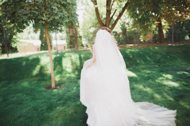 Gelinlik içinde dışarıda poz veren güzel gelin.