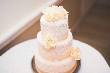 Masada süslü düğün pastası var.