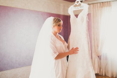 Beyaz elbiseli lüks gelin düğün törenine hazırlanırken poz veriyor.