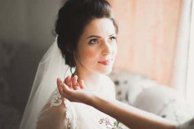 Tüylü, lüks makyaj, saç stili, stüdyo içi fotoğraf çekimi olan güzel bir gelin.