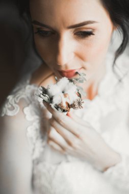 Gelin çiçekli büyük ve güzel bir düğün buketi tutuyor.