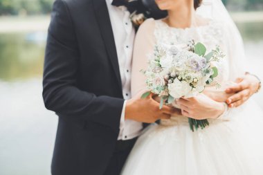 Yeni evli çift el ele tutuşurken parkta koşup zıplıyorlar.