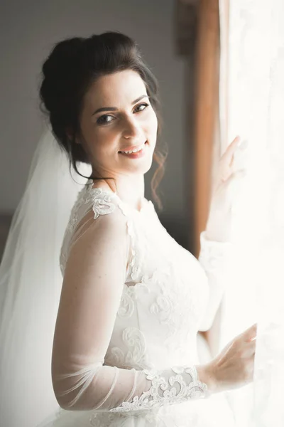 Розкішна наречена в білій сукні позує, готуючись до весільної церемонії — стокове фото