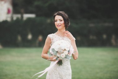 Gelinlik içinde dışarıda poz veren güzel gelin.