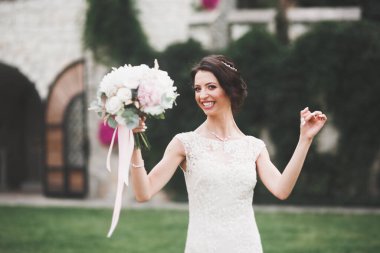 Parkta poz veren zarif beyaz elbiseli güzel gelin.