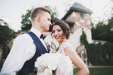 Güzel, mutlu bir düğün çifti, güzel şehirde uzun beyaz elbiseli bir gelin.