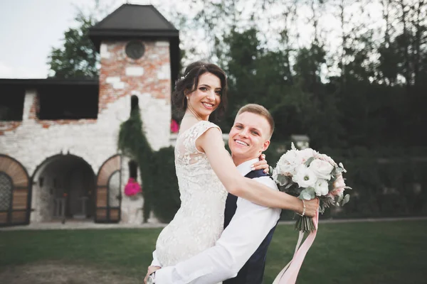 素敵な幸せな結婚式のカップル、美しい街でポーズをとる長い白いドレスの花嫁 — ストック写真