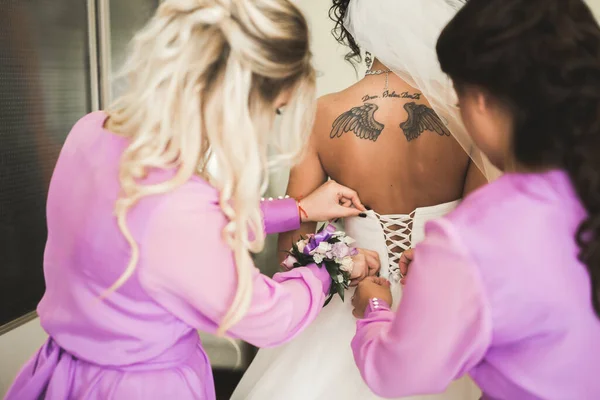 Preciosa novia en bata posando y preparándose para la ceremonia de boda cara en una habitación — Foto de Stock