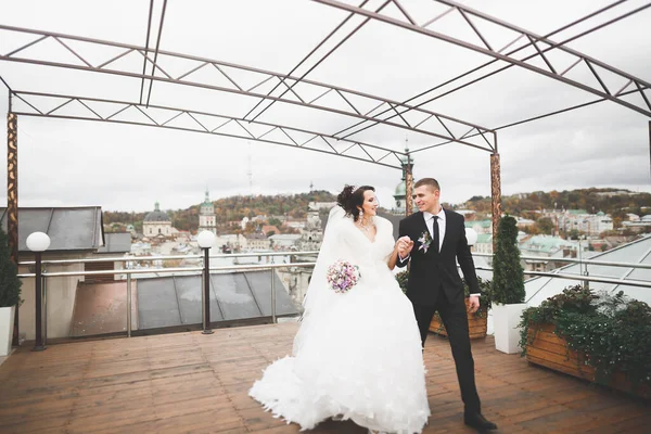 Casal feliz encantador do casamento, noiva com vestido branco longo posando na cidade bonita — Fotografia de Stock