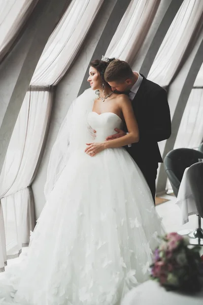 Casal feliz encantador do casamento, noiva com vestido branco longo posando na cidade bonita — Fotografia de Stock