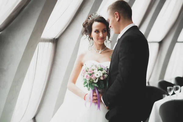 Ravissant couple de mariage heureux, mariée avec longue robe blanche posant dans la belle ville — Photo