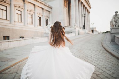 Çekici gelinin portresi, uzun saçlı, büyük buketli poz veren.