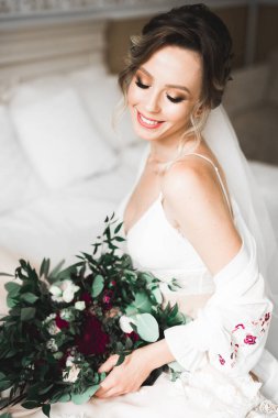 Tüylü, lüks makyaj, saç stili, stüdyo içi fotoğraf çekimi olan güzel bir gelin.