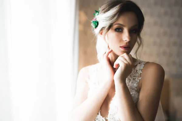 Belle mariée portant une robe de mariée de mode avec des plumes avec luxe délice maquillage et coiffure, studio séance photo d'intérieur — Photo