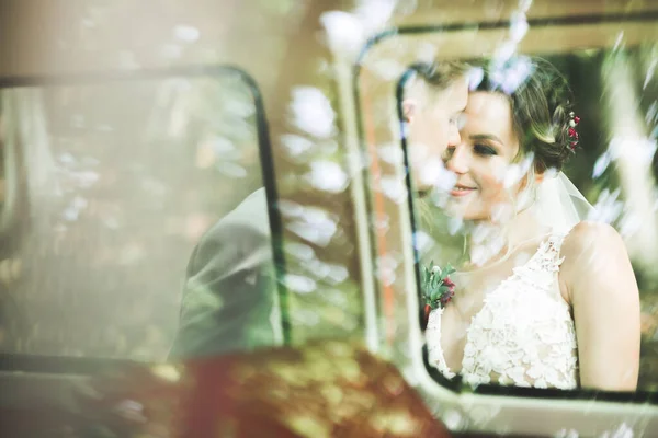 Hermosa pareja recién casada posando cerca de coche retro —  Fotos de Stock