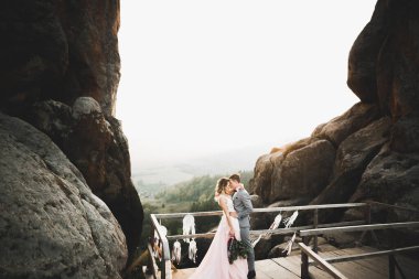 Düğün gününde damadın ve gelinin dağların eteklerinde mutlu mesut evlenecekler. Doğada mutlu evlilikler, yumuşak güneşli ışıklar.