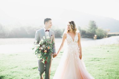 Duygusal güzel gelin, yeni evli damada yakın planda sarılıyor.