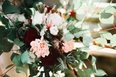 Gelin çiçekli büyük ve güzel bir düğün buketi tutuyor.