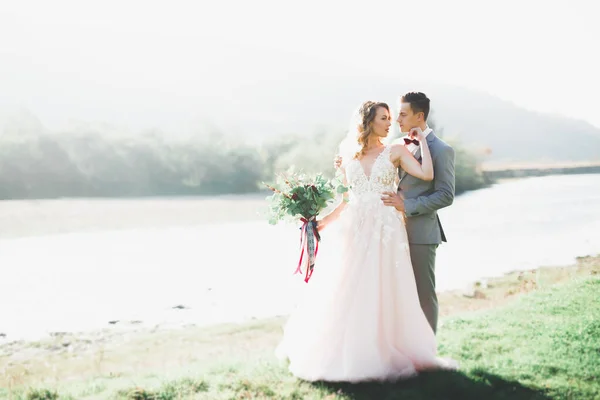 Emotionale schöne Braut umarmt frisch vermählten Bräutigam bei einem Feld Nahaufnahme — Stockfoto