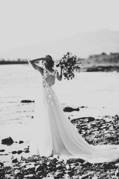 Ritratto di splendida sposa con lunghi capelli in piedi vicino al fiume — Foto Stock