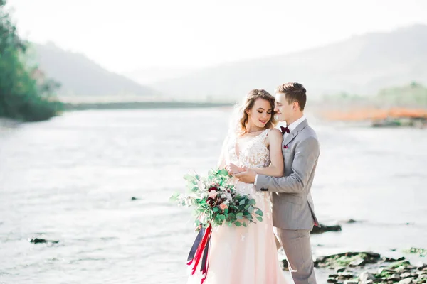 Boda pareja, novio y novia abrazos, al aire libre cerca del río —  Fotos de Stock