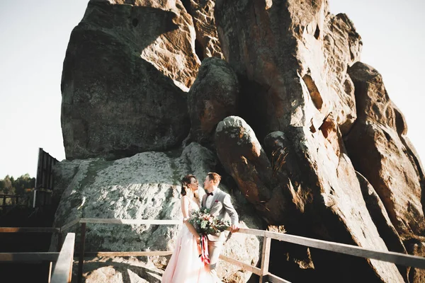 Красивая невеста с букетом на горном фоне на закате — стоковое фото