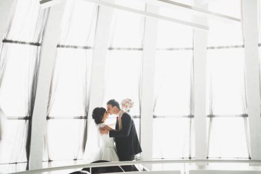 Güzel, mutlu bir düğün çifti, güzel şehirde uzun beyaz elbiseli bir gelin.