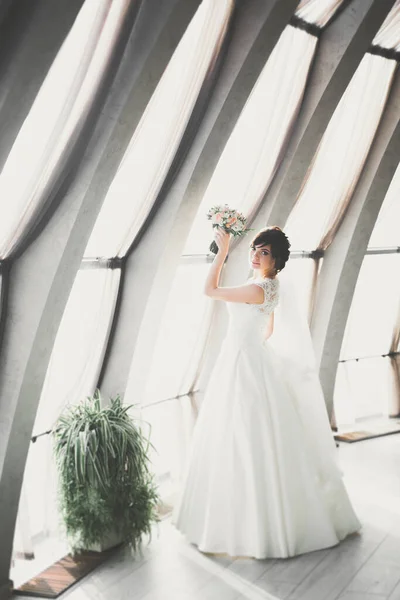 Retrato de novia impresionante con el pelo largo posando con gran ramo — Foto de Stock