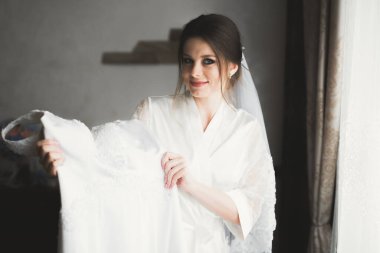 Beyaz elbiseli lüks gelin düğün törenine hazırlanırken poz veriyor.