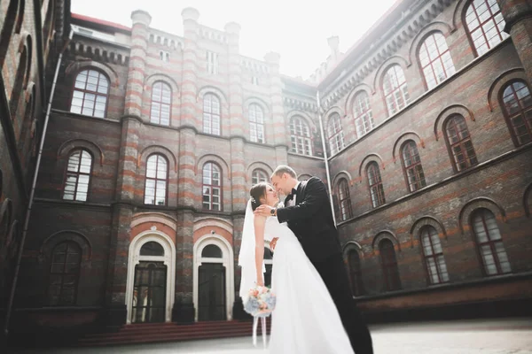 Härligt lyckligt bröllop par, brud med lång vit klänning — Stockfoto