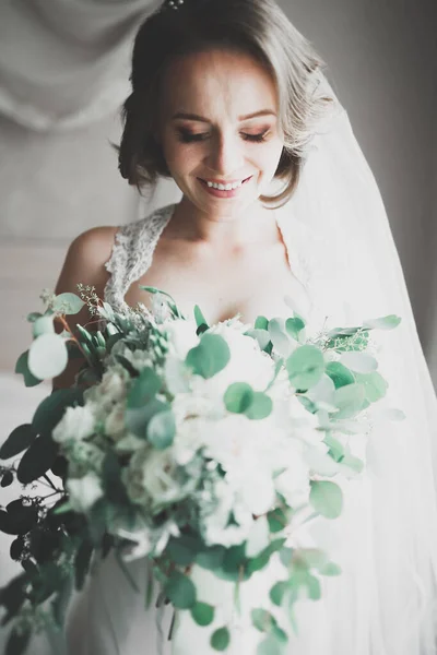 Linda noiva em roupão posando e se preparando para o rosto cerimônia de casamento em uma sala — Fotografia de Stock