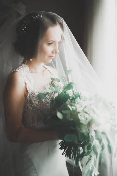 Gorgeous bride in robe posing and preparing for the wedding ceremony face in a room — Stock Photo, Image