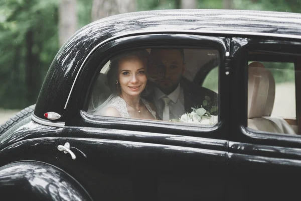 Apenas casal no carro retro de luxo em seu dia do casamento — Fotografia de Stock