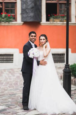 Güzel, mutlu bir düğün çifti, güzel şehirde uzun beyaz elbiseli bir gelin.