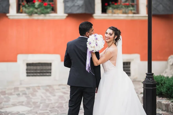 Nádherný šťastný pár stojící vedle sebe a dívající se do očí na pozadí starého města, svatební fotografie, Evropské město, svatební den ve Lvově — Stock fotografie