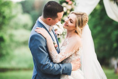 Romantik düğün anı, yeni evli çiftin gülümseyen portresi, gelin ve damadın kucaklaşması