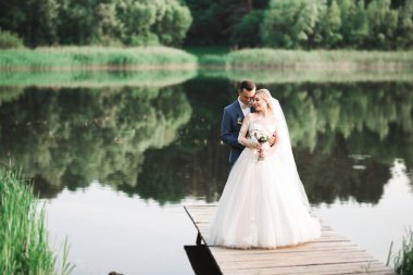 Romantik düğün anı, yeni evli çiftin gülümseyen portresi, gelin ve damadın kucaklaşması