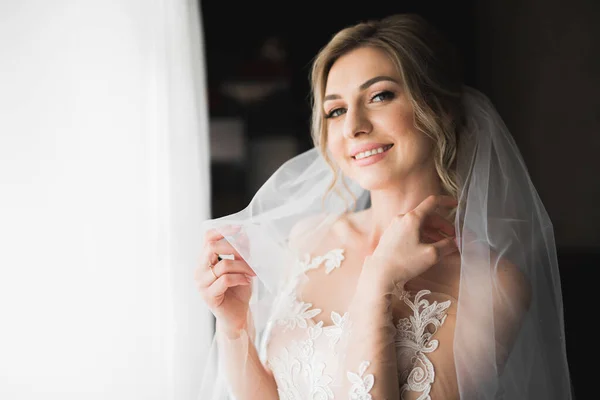 Novia de lujo en vestido blanco posando mientras se prepara para la ceremonia de boda —  Fotos de Stock