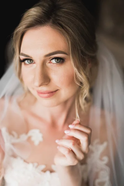 Noiva de luxo em vestido branco posando enquanto se prepara para a cerimônia de casamento — Fotografia de Stock