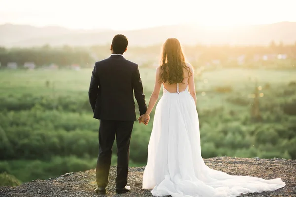 Esküvő pár kéz a kézben, vőlegény és menyasszony együtt az esküvő napján — Stock Fotó