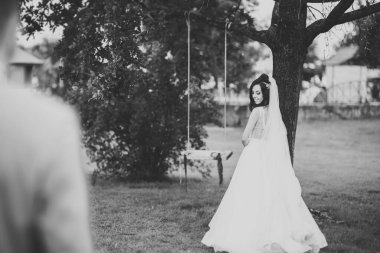 Parkta poz veren gelinlikli güzel, lüks bir gelin.