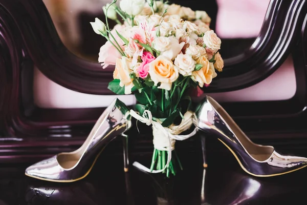 Par de zapatos de novia elegantes y elegantes con un ramo de rosas y otras flores . — Foto de Stock