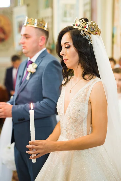 Mariée et marié tenant des bougies à l'église — Photo