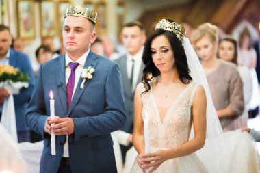 Gelin ve damat kilisede mum tutuyorlar.