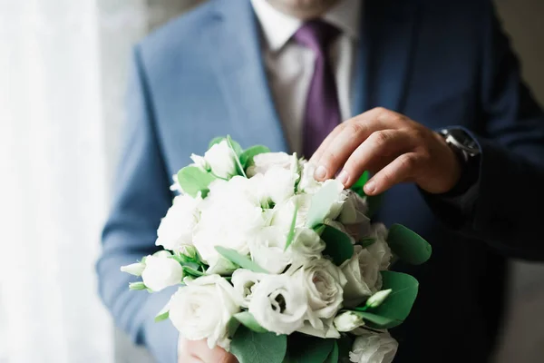 Homem bonito, noivo segurando grande e bonito buquê de casamento com flores — Fotografia de Stock